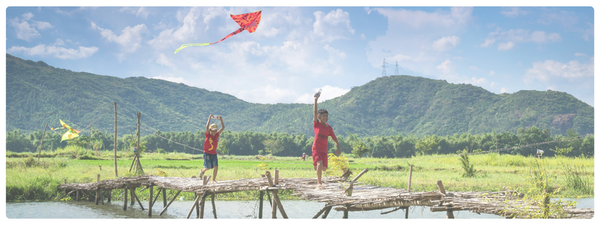 Kids fly a kite over a bridge